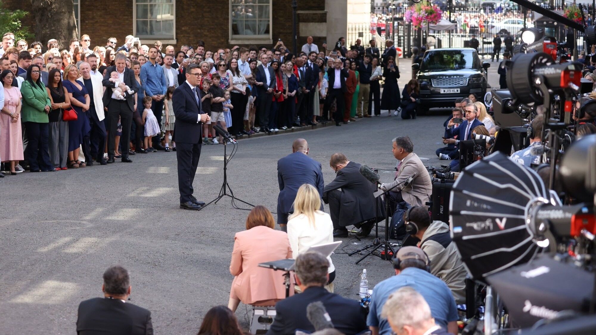 Andy Burnham speaks at a podium outside 10 Downing Street, facing a large crowd and assembled media after becoming UK prime minister.